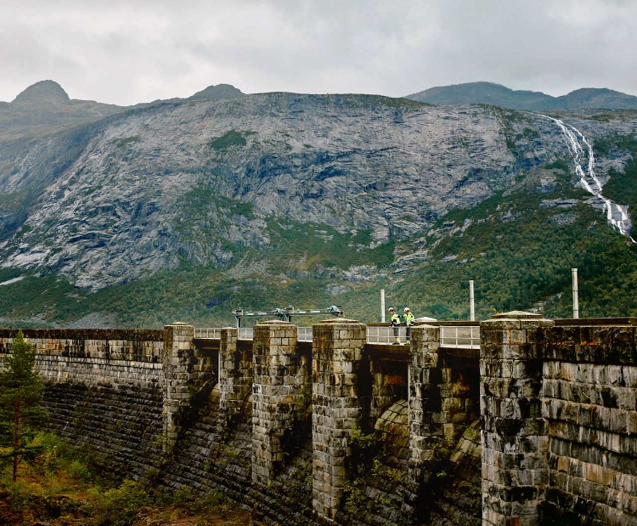 To menn stående på demning